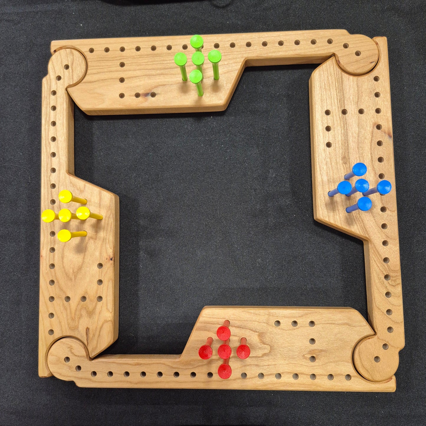 A Wooden, handcrafted Jokers and Pegs Game for up to four players. The game is easily expanded for up to eight players by adding extra pieces